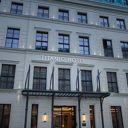 柏林御林广场泰坦尼克酒店 外观 照片 The photo shows the exterior of a building identified as the "Titanic Hotel." The facade features a clean, modern design with multiple windows and a prominent sign that displays the hotel name. There are decorative elements, including a covered entra